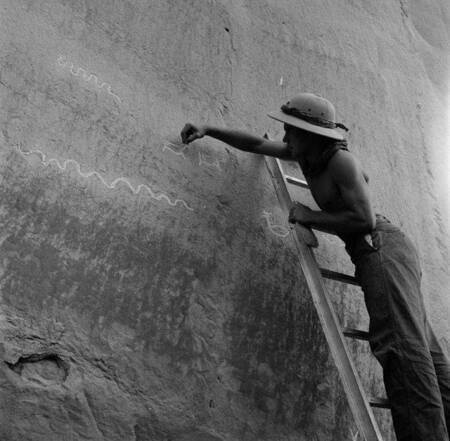 Man chalking in petroglyphs