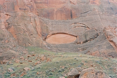 Rock formations and grassy hillside below Glen Canyon Dam