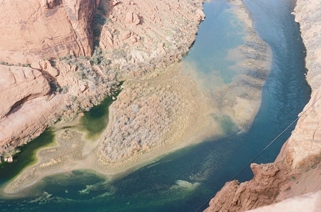 the Colorado River and a grassy sandbar immediately below Glen Canyon Dam