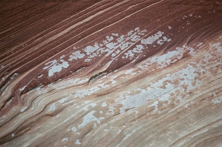 Ironized rock striations, reexposed and flecked with mineral crust from Lake Powell